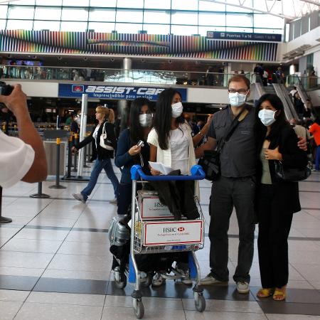 Turistas posam para foto no aeroporto - REUTERS