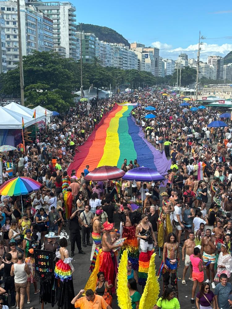 Público estende bandeira arco-íris na avenida Atlântica, em Copacabana, durante a Parada do Orgulho LGBTI+ do Rio, no domingo (24)