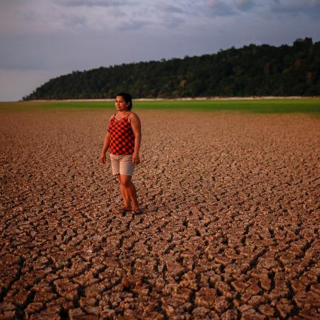 Mulher caminha pelo leito seco de afluente do rio Tapajós, na Amazônia - Amanda Perobelli - 10.out.2024/Reuters