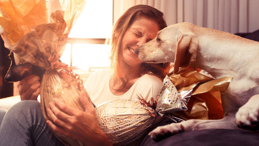 Cachorro com mulher e ovos de Páscoa - Getty Images/iStockphoto