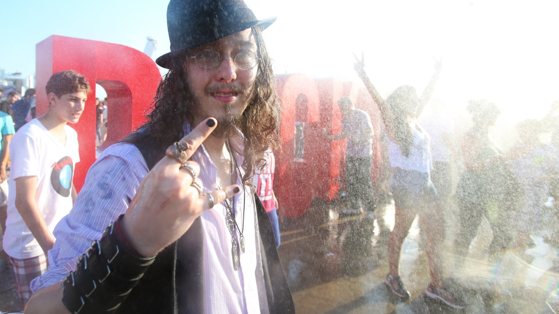 18.set.2015 - Com a temperatura batendo os 38º C e sensação térmica de 40º C, público que chega à Cidade do Rock, para curtir o primeiro dia de Rock in Rio, tenta se refrescar do jeito que dá, sem perder o estilo rock and roll - Marco Antônio Teixeira/UOL