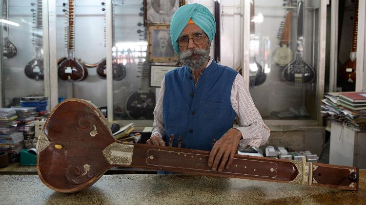 Ajit Singh, 86, dono da loja de instrumentos que consertou a guitarra de Lennon e tocou no aniversário de 25 anos de George Harrison - Sajjad Hussain/AFP - Sajjad Hussain/AFP