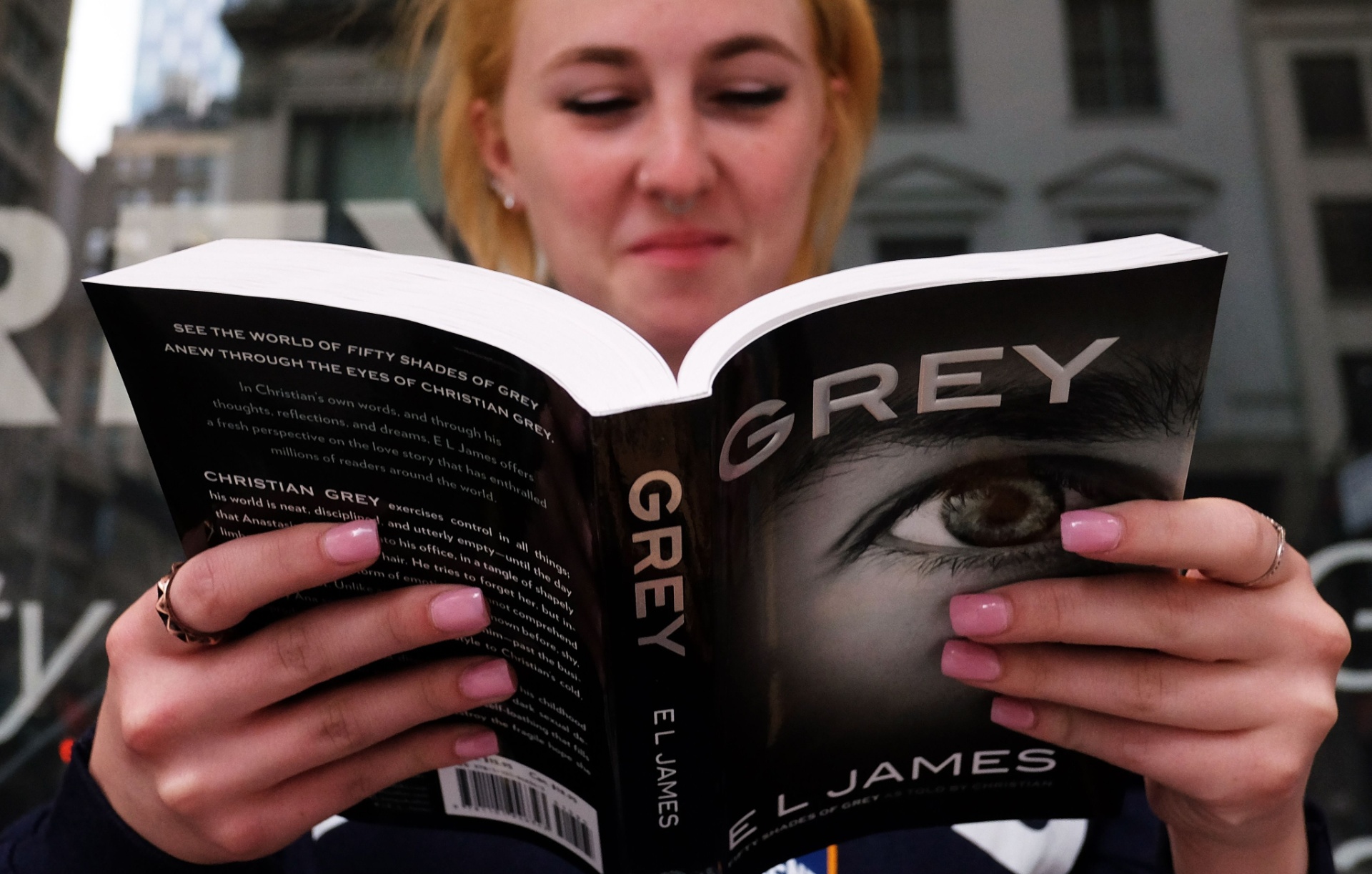 18.jun.2015 - Mulher sai da loja em Nova York com seu exemplar de "Grey", que reconta a história de "Cinquenta Tons de Cinza" sob o olhar de Christian Grey - AFP PHOTO/JEWEL SAMAD