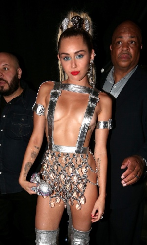 30.ago.2015 - Apresentadora do Video Music Awards 2015, Miley Cyrus atrai toda atenção ao chegar no tapete vermelho com look transparente e decotado