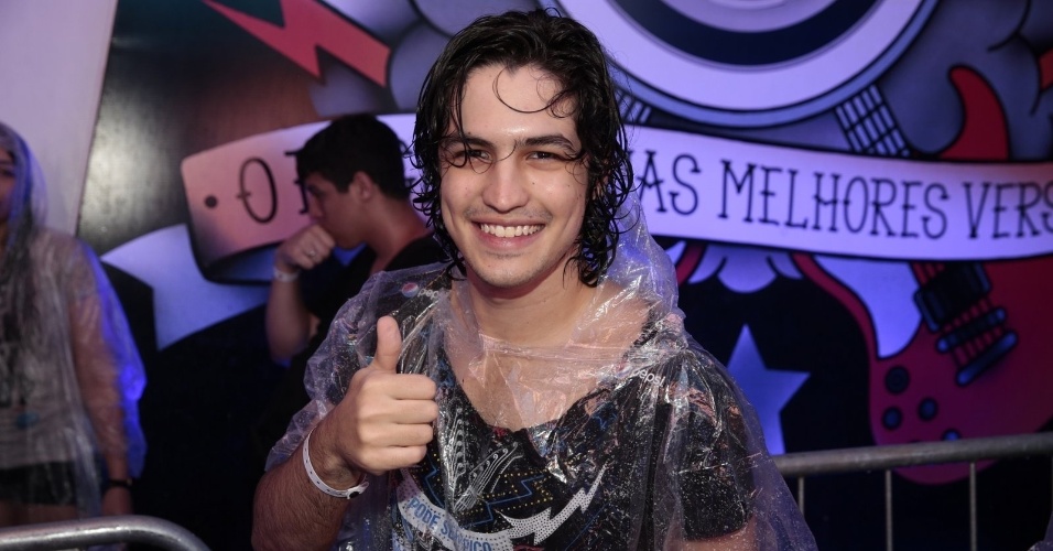 27.set.2015 - Com capa de chuva, Gabriel Leone aparece de cabelos molhados após acompanhar show do último dia de Rock in Rio