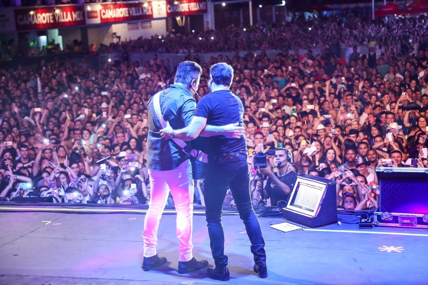20.nov.2015 - Convidado ao palco do festival Villa Mix, Chimbinha abraça o sertanejo Marrone, da dupla com Bruno - Caio Duran / Azzi Agency / Divulgação