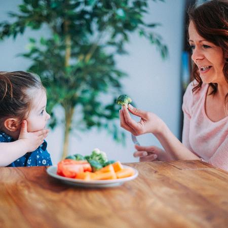 Criança comendo vegetais/ Criança alimentação saudável/ Dar comida para criança - iStock