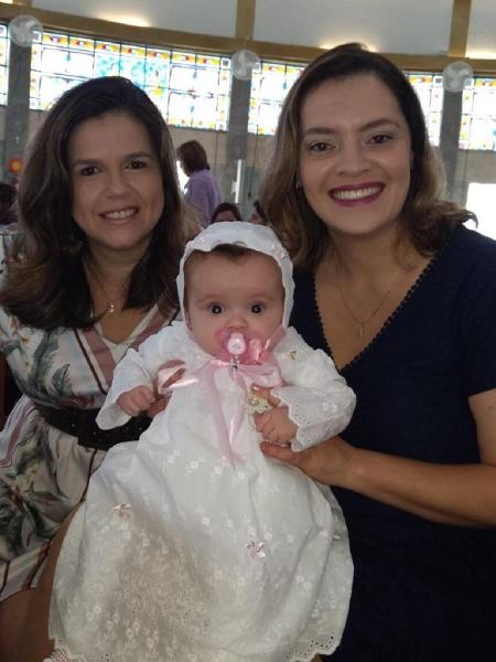 Gislene, com a mulher, Amanda, e a filha Manu, no dia do batizado da criança na Igreja Católica  - Arquivo pessoal