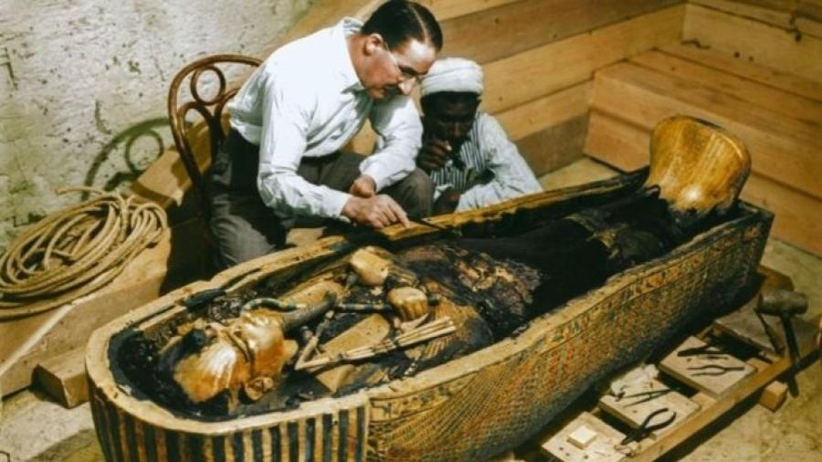 Arqueólogo britânico Howard Carter e um trabalhador egípcio examinam um caixão feito de ouro maciço dentro da tumba - Griffith Institute