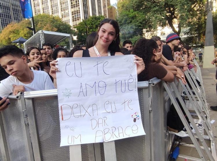 Camila Cândido, fã de Matuê, aguarda show do cantor com cartaz em mãos na Virada Cultural