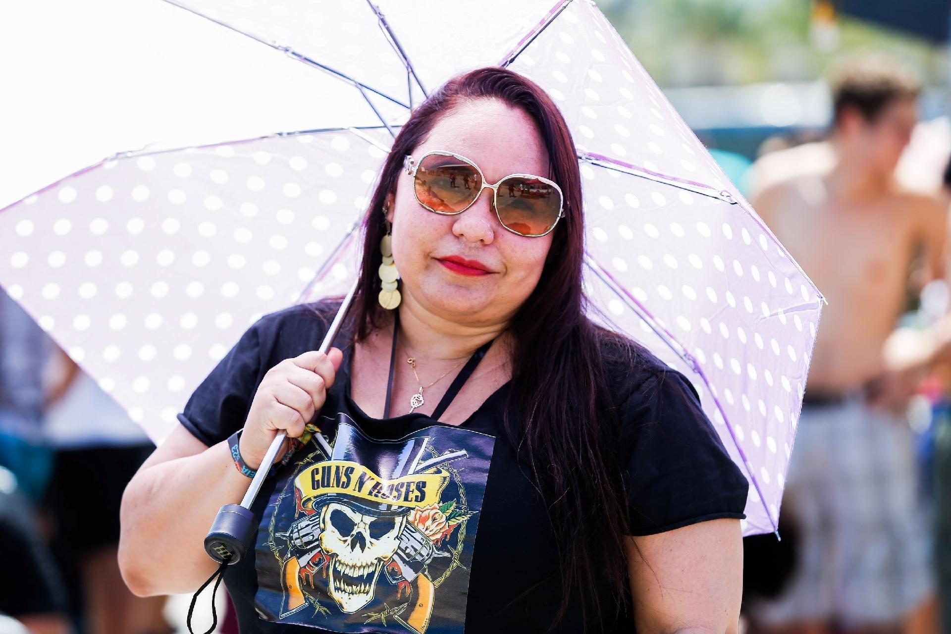 Fã do Guns, Gabriela Dantona se protege do sol em frente a Cidade do Rock - Marco Antonio Teixeira/UOL