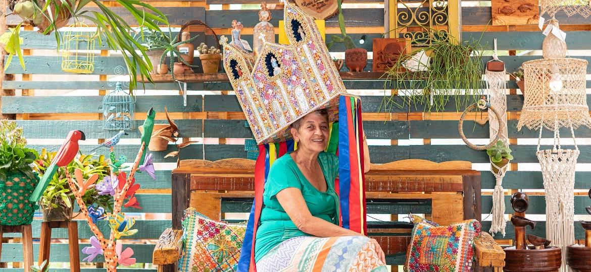 Dona Vânia vestindo seu chapéu de Guerreiro, peça do folclore alagoano que pode pesar até 8 quilos - Ramatis Haywanon da Costa/Divulgação