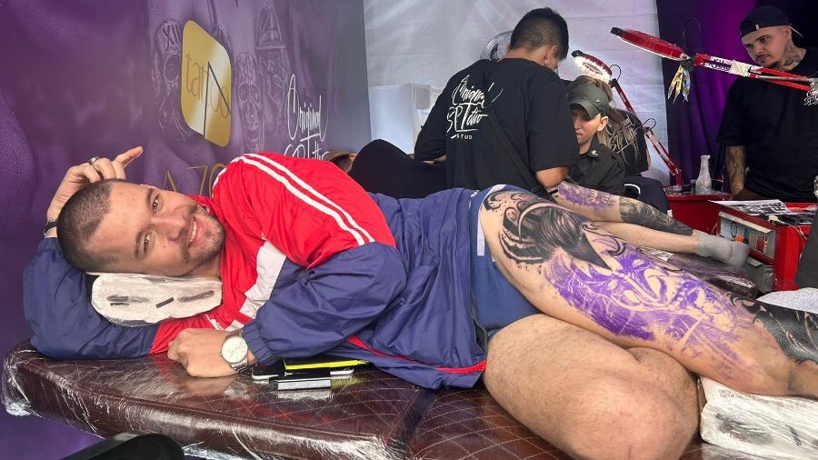 Felipe Oliveira, 33, ficou deitado em um stand de tatuagem por seis horas no festival Somos Rock