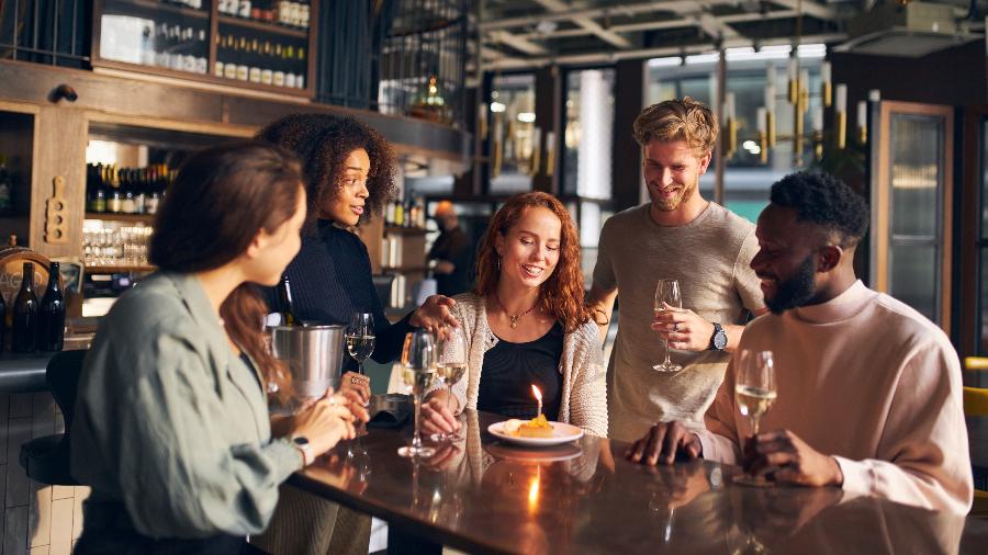 Amigos fazem aniversário em restaurante - Getty Images/iStockphoto