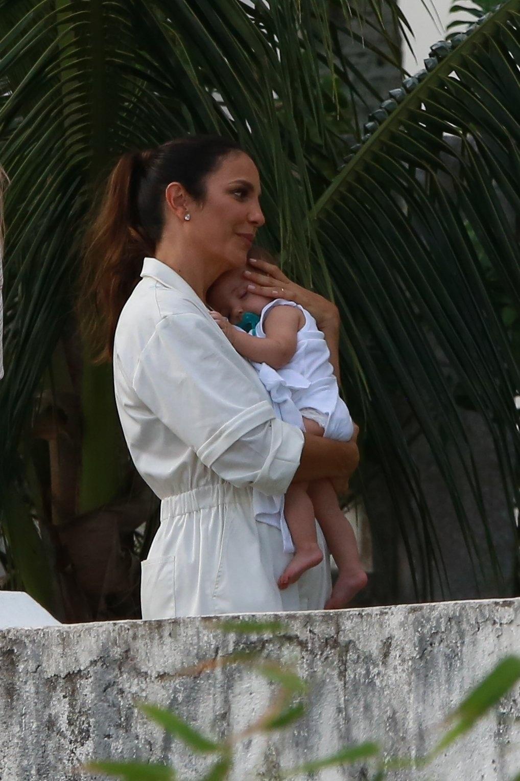 Mamãe Ivete faz carinho em uma das gêmeas no colo para dormir  logo depois do batismo - AgNews/Dilson Silva