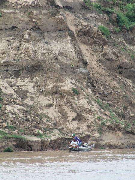 Pescadores trabalham próximo a um deslizamento (ou terras caídas), às margens do Rio Solimões, no Amazonas