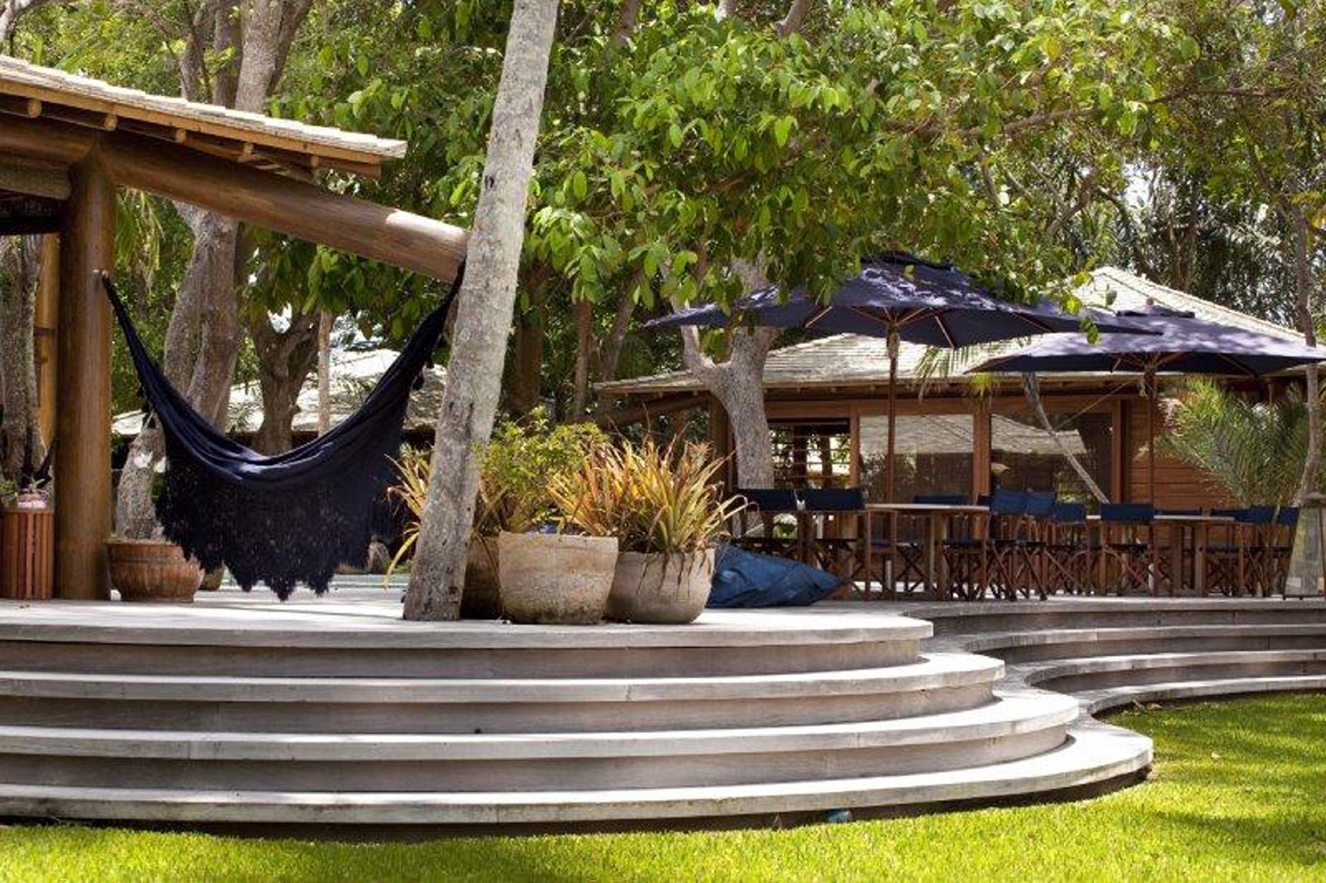 Sinônimo de descanso, as redes com rendas sempre fazem parte dos projetos do arquiteto baiano David Bastos. Ele prefere as cores sóbrias, pois são mais fáceis de combinar com o restante da decoração. Neste projeto, ele aproveitou o tronco resistente de um árvore e a estrutura do anexo de lazer para fixar os ganchos - Divulgação