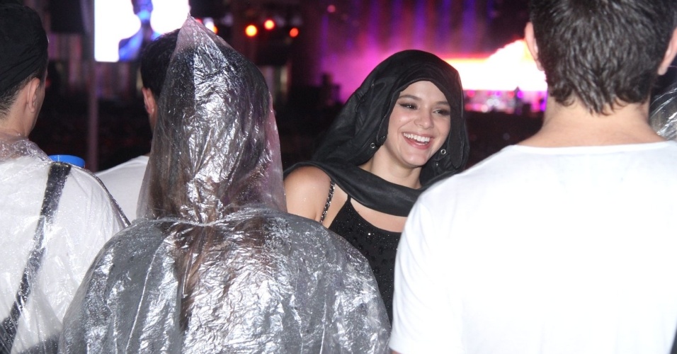 27.set.2015 - Em dia de chuva no Rock in Rio, Bruna Marquezine improvisa capa com casaco para curtir show na pista. Ela estava acompanhada por Thaila Ayala (de costas)