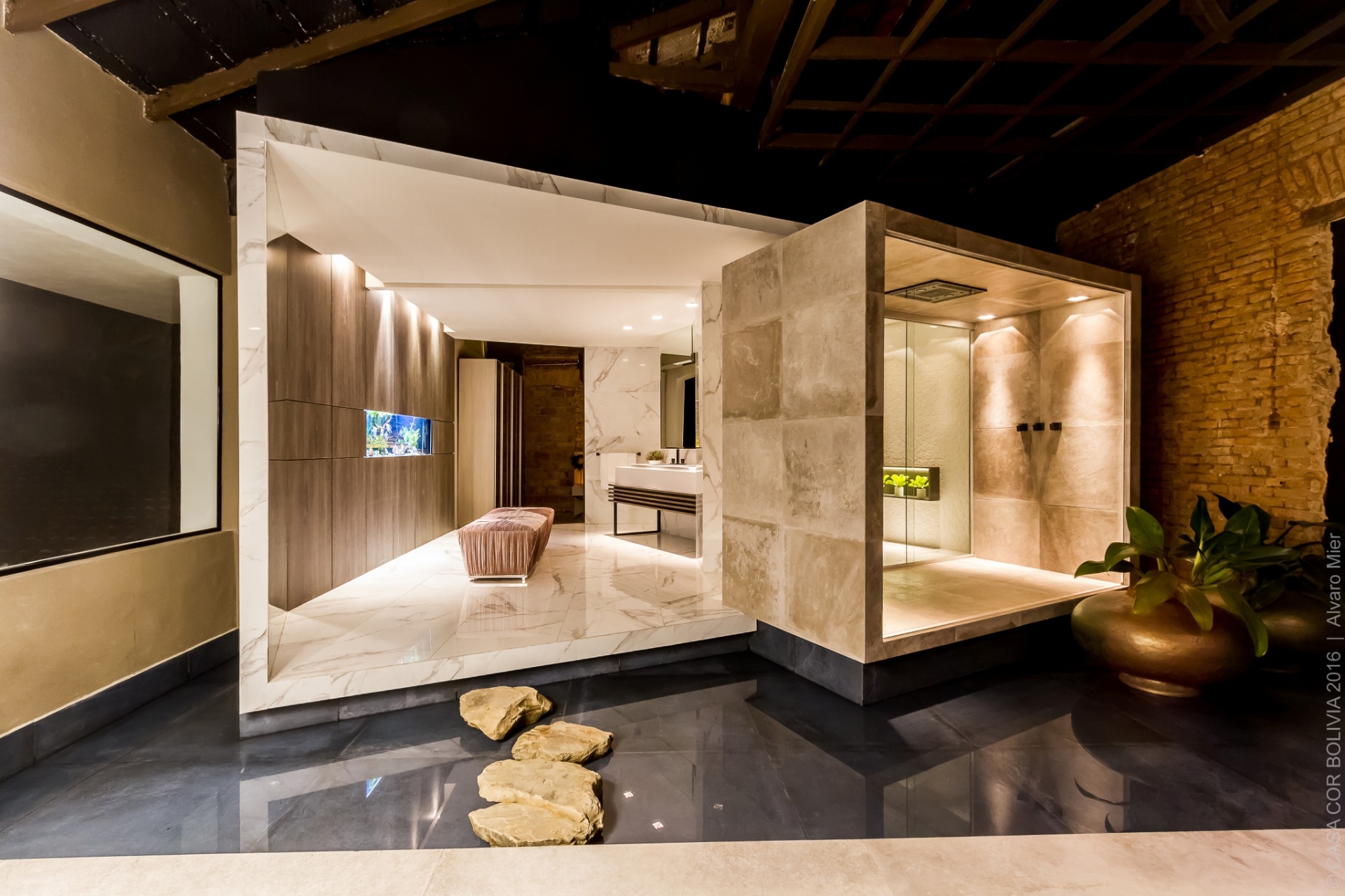 Conforto, elegância e luxo são as caraterísticas da Cobertura DECA, criada pelo arquiteto Humberto Beltrán, exibida na Casa Cor Bolívia 2016. A suíte, que é separada do resto da casa por um vidro, combina cores neutras com materiais nobres, como mármore, madeiras escuras e pedras naturais. Plantas, aquário grande para peixes e obras de arte na parede deixam o espaço ainda mais sofisticado - Alvaro Mier/ Divulgação
