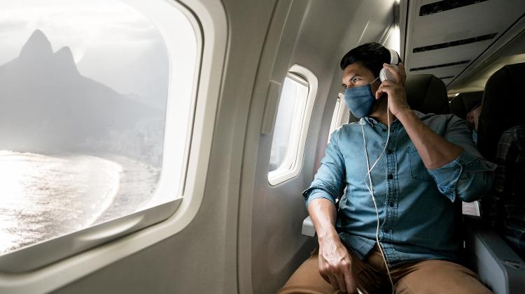homem no avião com máscara no rio de janeiro, pandemia, covid, viagem, turismo - Getty Images - Getty Images