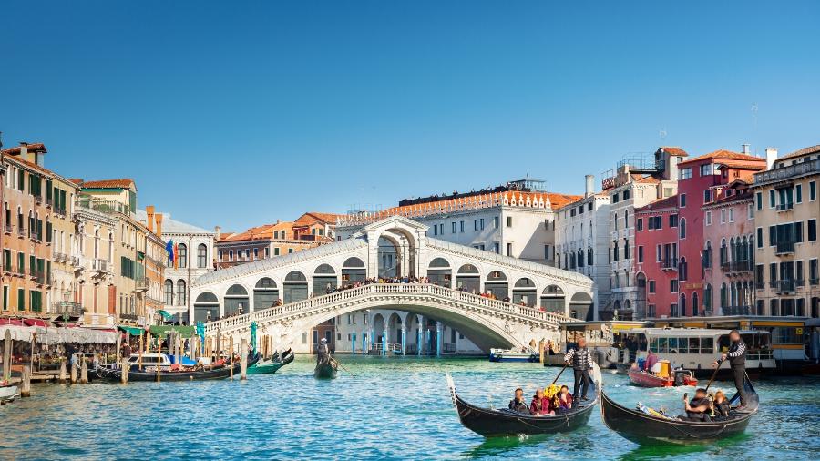 Gondoleiros tradicionalmente conduzem os turistas em passeios de barco pelos canais de Veneza - adisa/Getty Images/iStockphoto