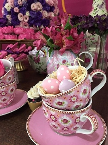 As xícaras decoradas com estampas florais viraram ninhos para ovinhos de plástico pintados com bolinhas brancas. O bule tornou-se um charmoso cachepô para as astromélias cor-de-rosa que decoraram o chá de fraldas - Divulgação