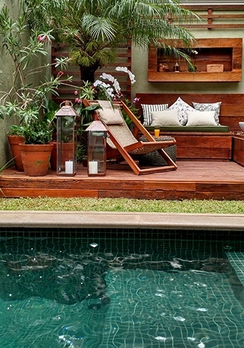 No jardim criado pela paisagista Gigi Botelho, ao lado da piscina, está um deck suspenso de madeira de demolição. Sobre a plataforma, além da cadeira de corda, há uma palmeira fênix (Phoenix Roebelinii) e vasos de espirradeira (Nerium oleander), zamia (Zamia furfuracea) e pacová (Philodendron martianum). Para arrematar o ambiente, lanternas de cobre - Divulgação