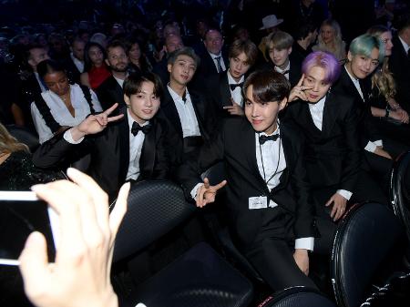 Os integrantes do BTS tiram foto na plateia do Grammy 2019 - Getty Images
