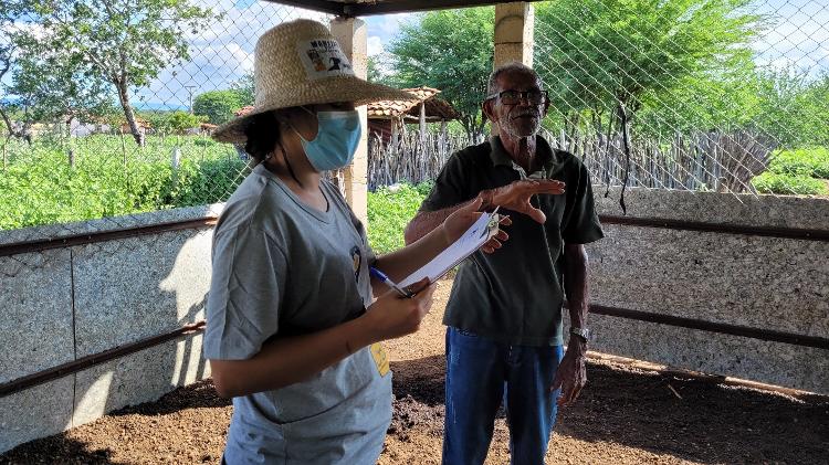 Pesquisadora do Programa Amigos da Onça junto a produtor rural local em visita a chiqueiro para caprinos à prova de ataques de onças. 