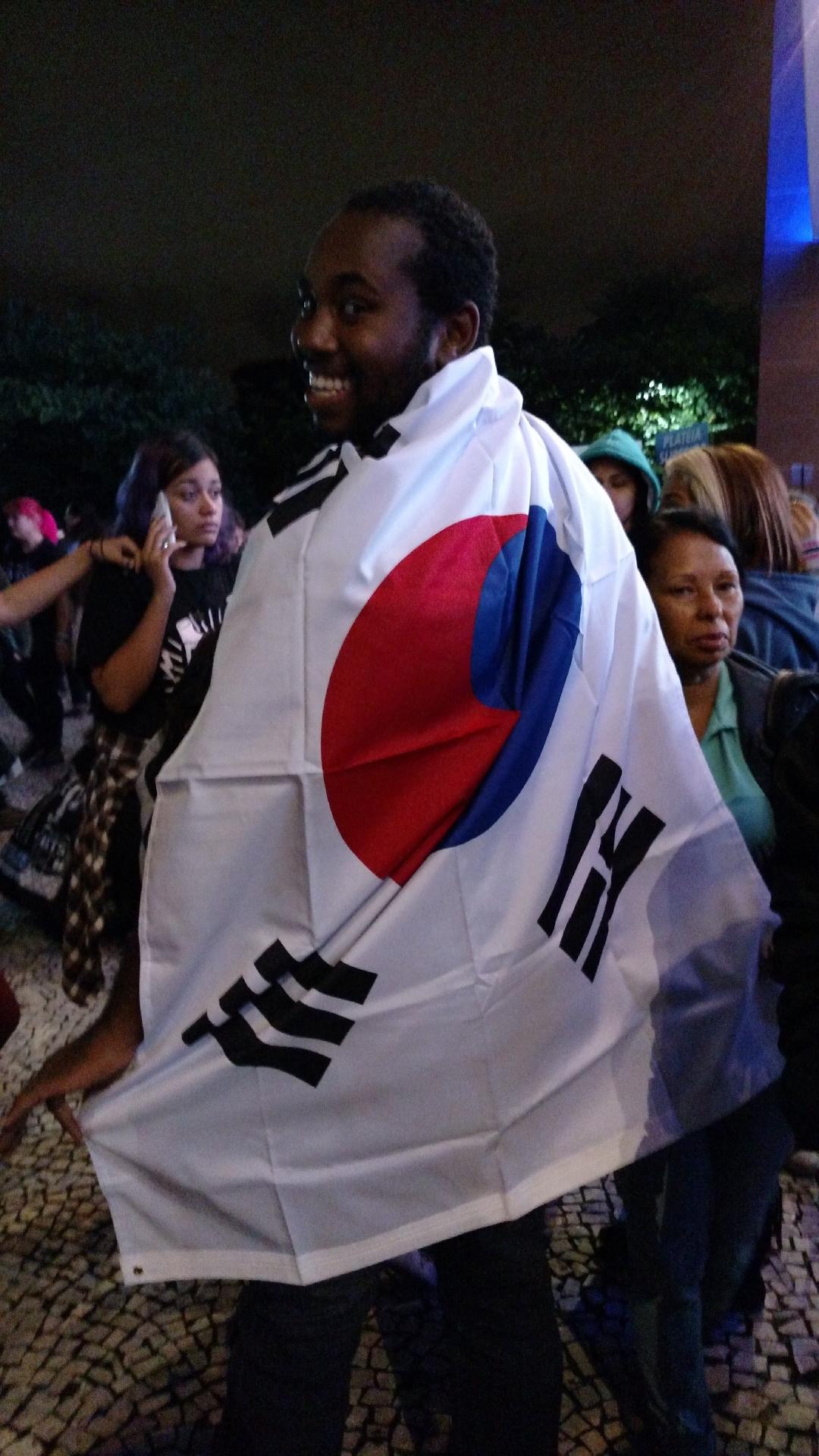 Marcelo Alex, 20, levou a bandeira sul-coreana para organizar o grupo de 160 pessoas que ele trouxe do Rio de Janeiro para São Paulo com uma empresa especializada em caravanas para shows de k-pop - Renata Nogueira/UOL