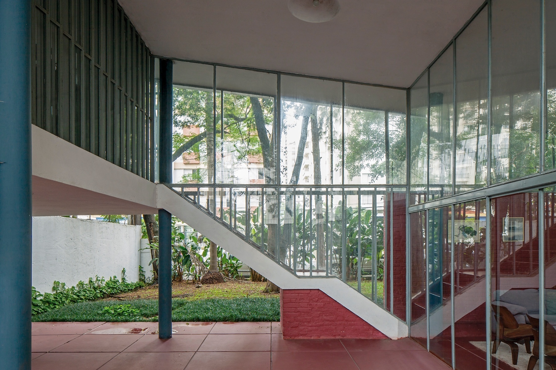 O terraço com pé-direito duplo é voltado para a rua e para os fundos. No espaço, o destaque é o perfil da escada que conduz ao mezanino, onde está o estúdio. A Casa do Arquiteto foi projetada por João Batista Vilanova Artigas, em 1949 - Leonardo Finotti/ UOL