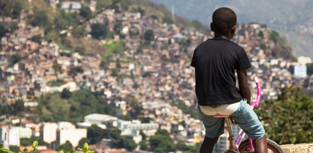 Menino observa o morro da Mineira, no Rio, de sua bicicleta - Lucas Almeida/Divulgação - Lucas Almeida/Divulgação