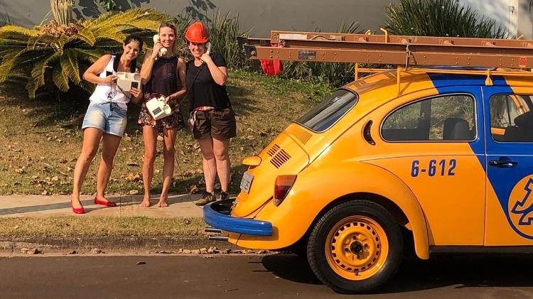 Amigas e mulher (à dir.) de Badolato posam com terminais telefônicos e capacete que vieram com o Fusca