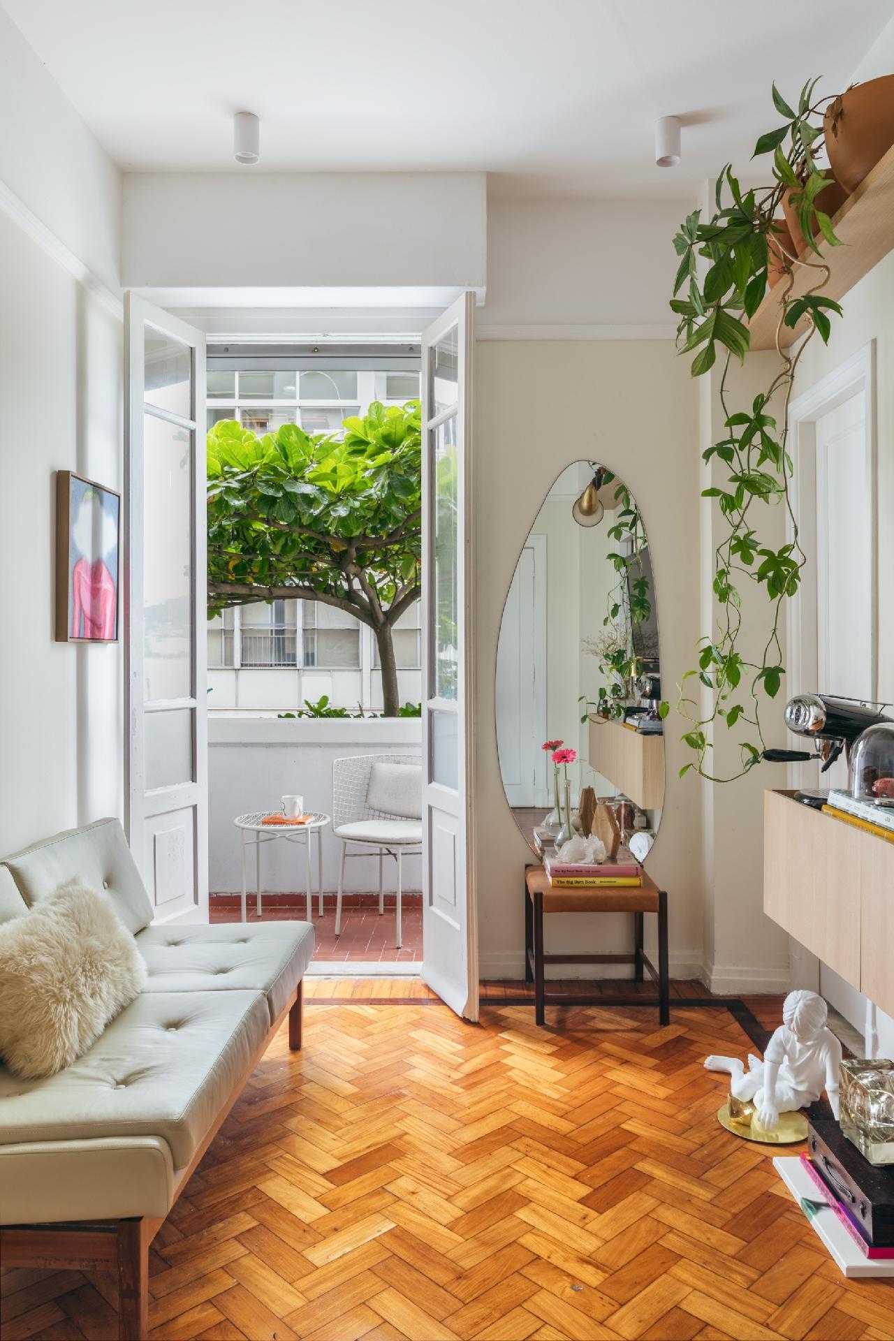 Quem vê a vista da sala para a varanda encontra a copa de uma castanheira, um dos encantos que fisgou Rodolfo. As portas altas estão sempre abertas. - Luiza Schreier/Divulgação