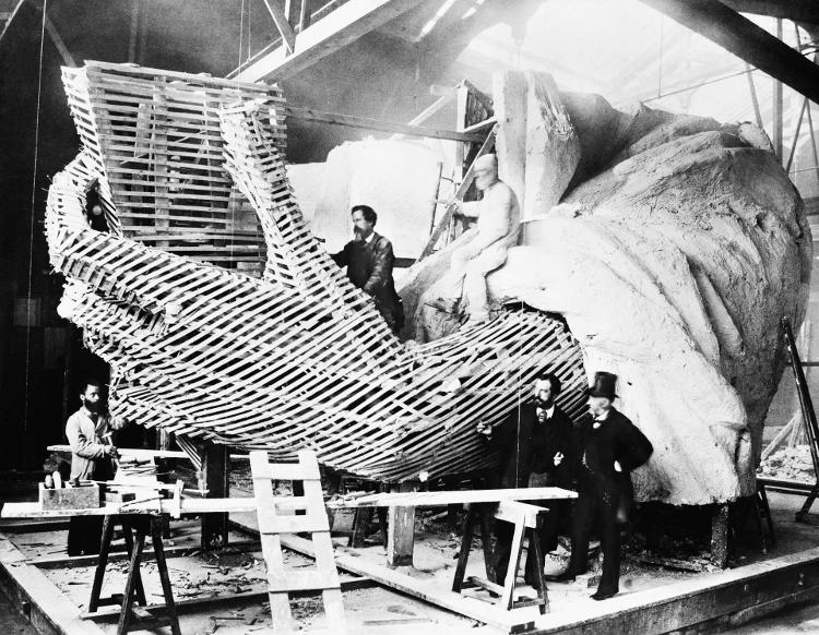 Frederic-Auguste Bartholdi, criador da Estátua da Liberdade, explicando o processo de construção da mão da imagem a um visitante