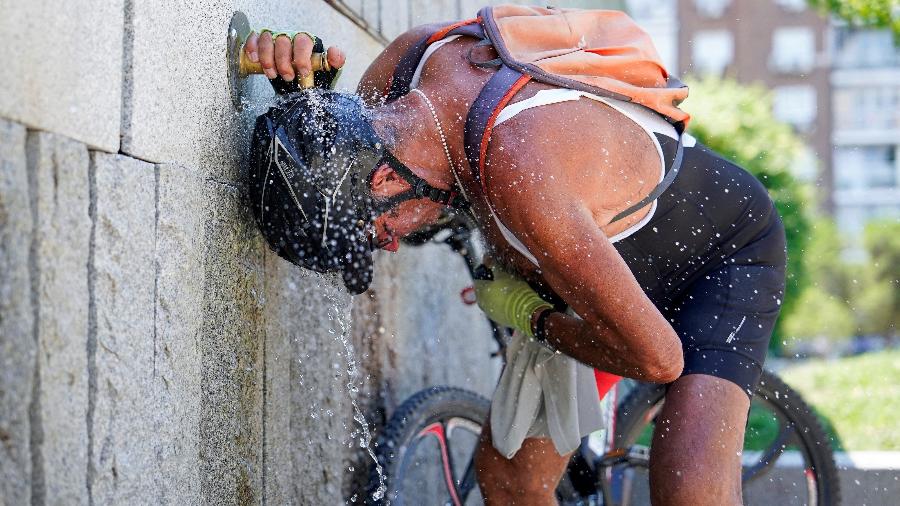 Ciclista se refresca em fonte de Madri em dia de calor na Espanha