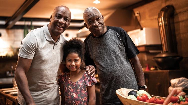 Idoso com parte da família, idoso com filho e neta - iStock - iStock