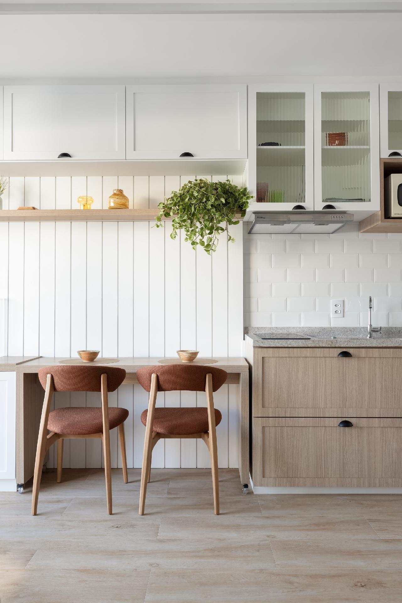 Ao lado da cozinha está a bancada de jantar - repare que ela pode se destacar da parede e se tornar mesa para ficar frente a frente, com rodízios. - Monica Assan/Divulgação