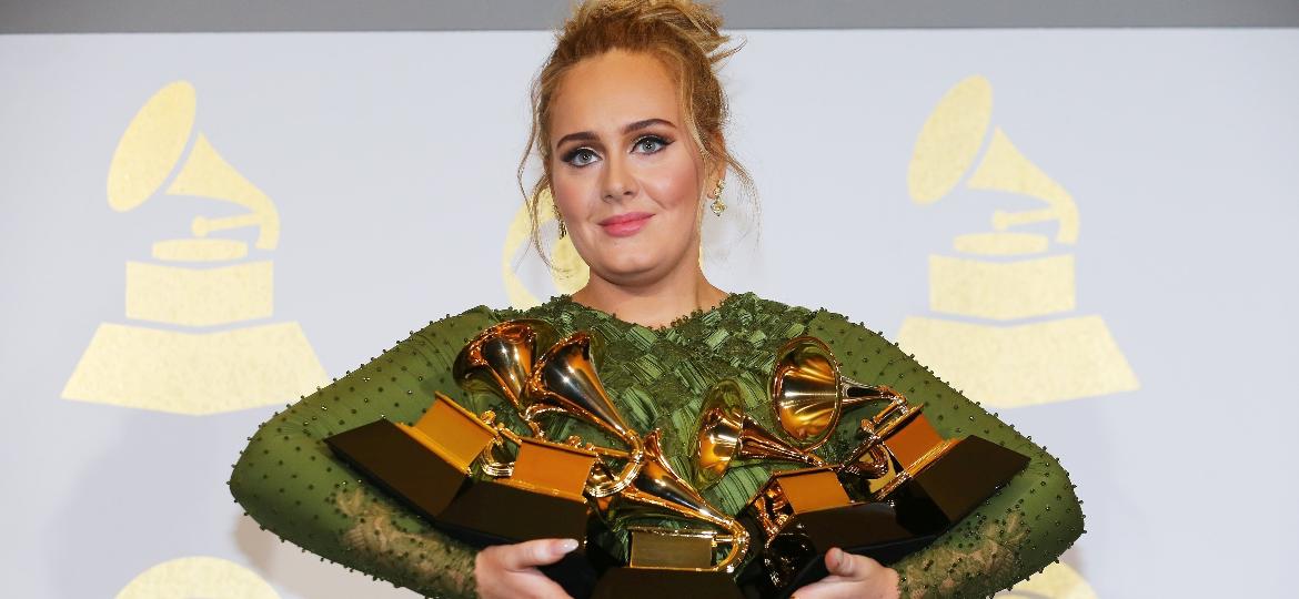 Adele com os cinco Grammys que ganhou na edição deste ano: álbum do ano, gravação do ano, música do ano, melhor performance solo e melhor álbum vocal pop - Mike Blake/Reuters