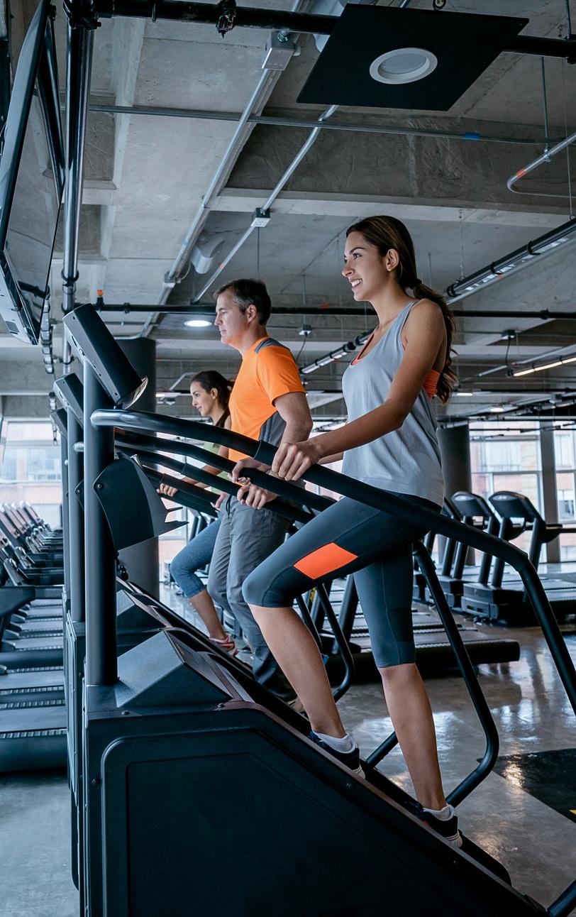 Mulher subindo escada na academia - andresr/Istock