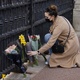 Mulher deixa flores no Palácio de Buckingham após o anúncio da morte do príncipe Philip - TOLGA AKMEN / AFP
