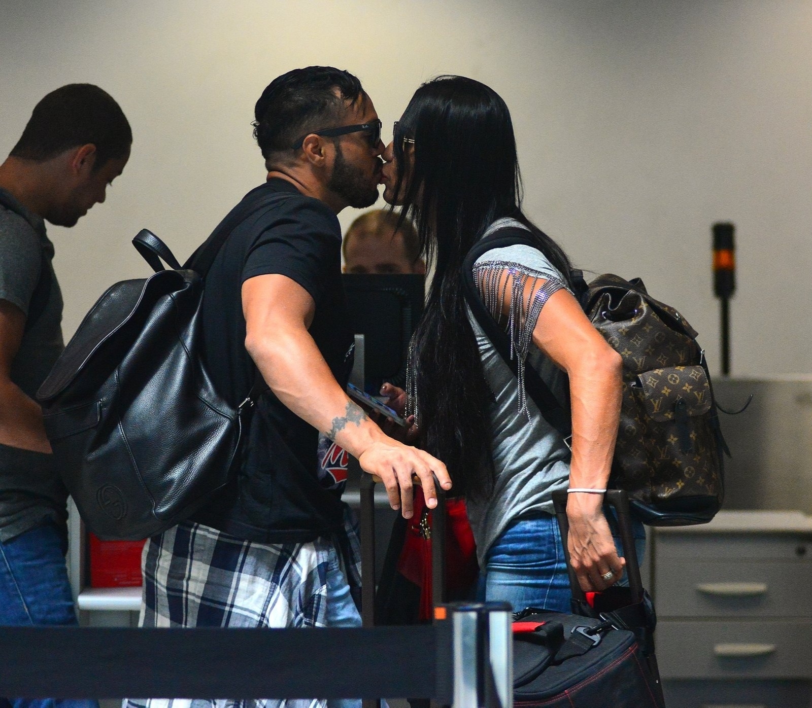 29.set.2015 - O cantor Belo e sua mulher, a dançarina Gracyanne Barbosa, trocaram beijos antes de embarcarem no aeroporto Santos Dumont, no Rio de Janeiro. O casal deu um selinho enquanto aguardava a fila do check-in. - William Oda/AgNews