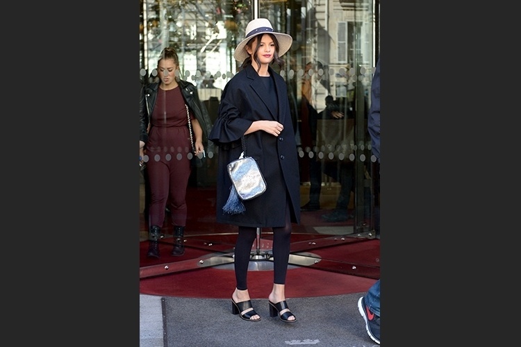 A cantora Selena Gomez desfilou elegância com seu casacão preto usado com legging transparente. O look todo preto ficou ainda mais interessante com os acessórios. O chapéu, a bolsa e o tamanco acrescentaram um toque de modernidade ao visual sóbrio - Grosby Group