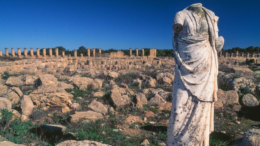 Estátua de figura feminina do período greco-romano em frente a ruínas de Cirene, na Líbia - De Agostini/Getty Images