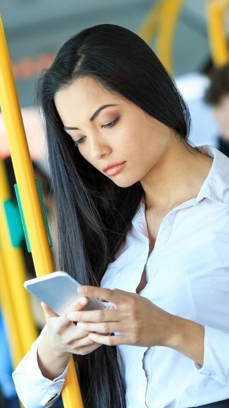 Mulher mexendo no celular na viagem de ônibus - Getty Images