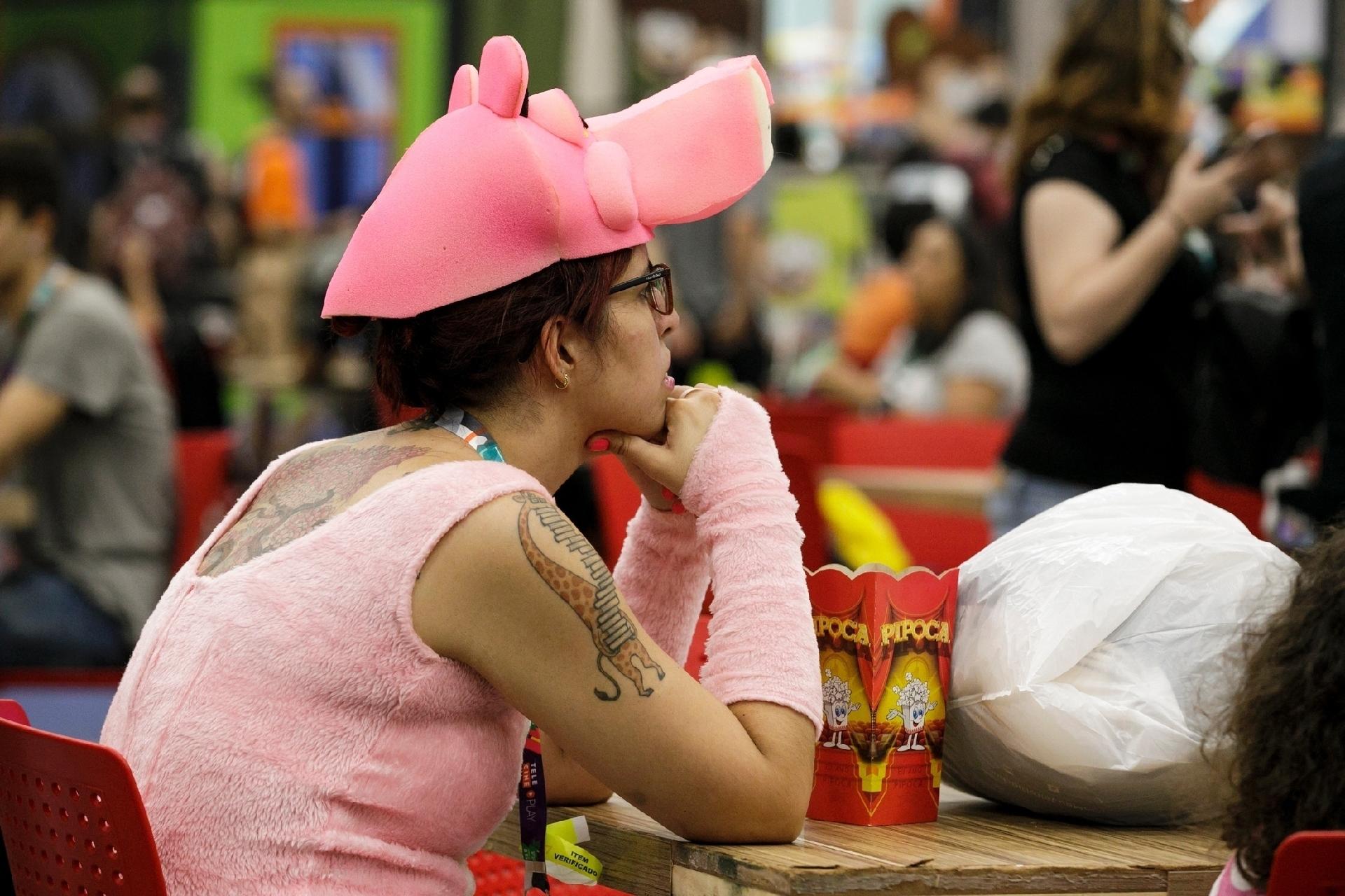 Pantera Cor-de-Rosa reflete na praça de alimentação e petisca uma pipoquinha - Mariana Pekin/UOL