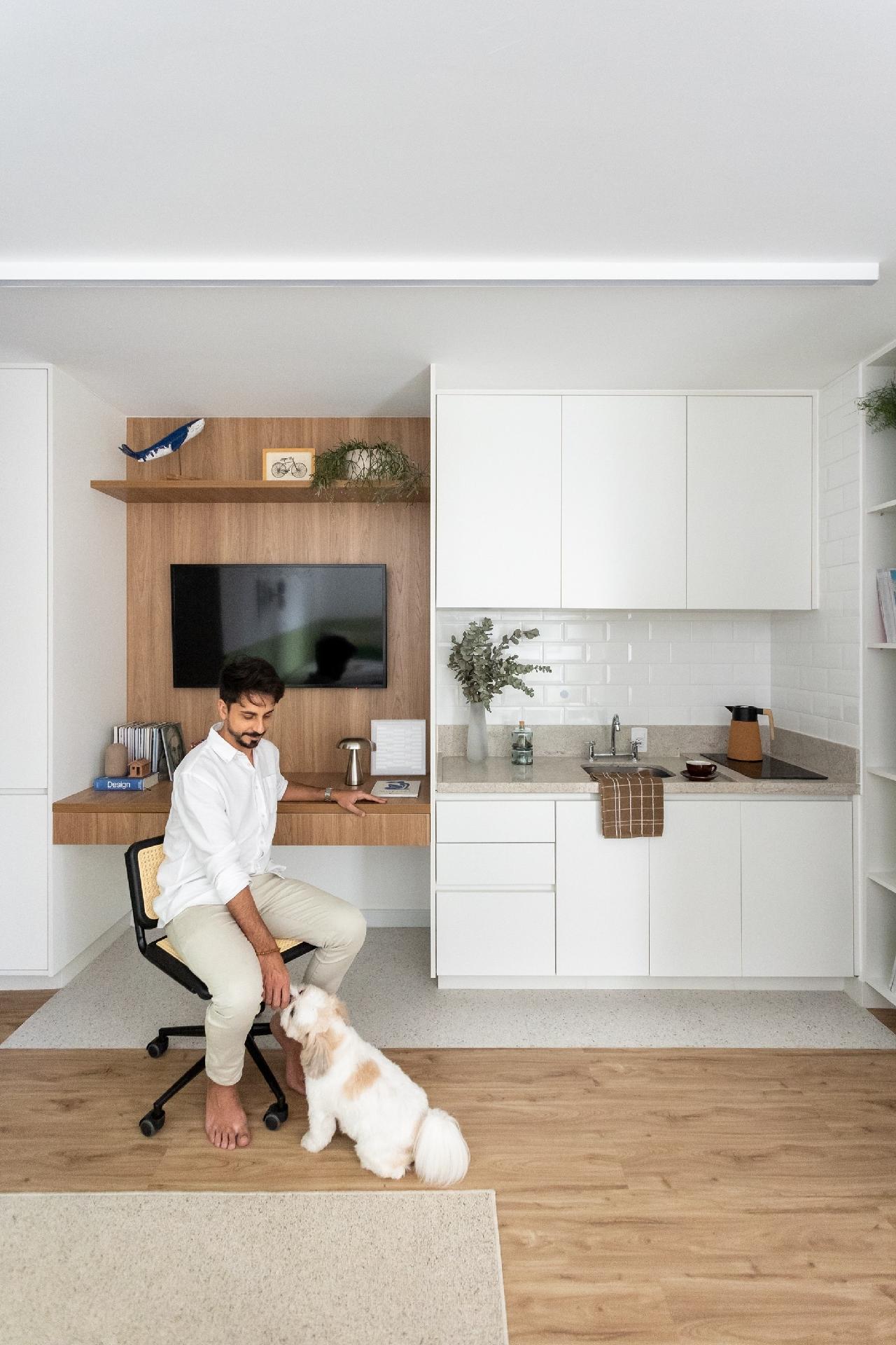 Logo ao lado está a cozinha em L, com armários sem puxadores, o que torna a estética mais limpa para uma cozinha ligada ao estar. - Thiago e Dam Mol/Divulgação