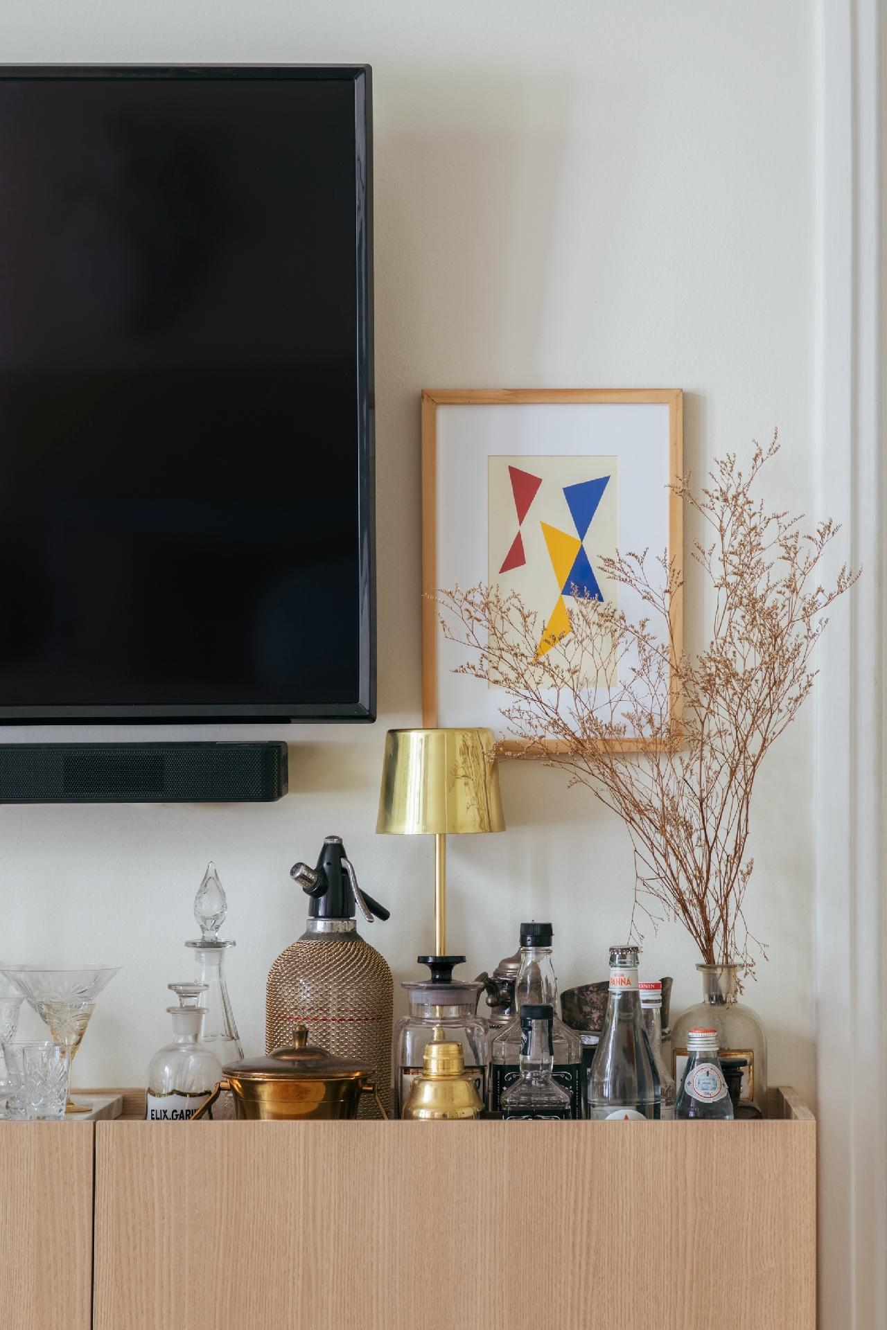 O espaço para o bar, no aparador, ganhou um rebaixo, uma solução que revela as bebidas de forma menos exposta. - Luiza Schreier/Divulgação