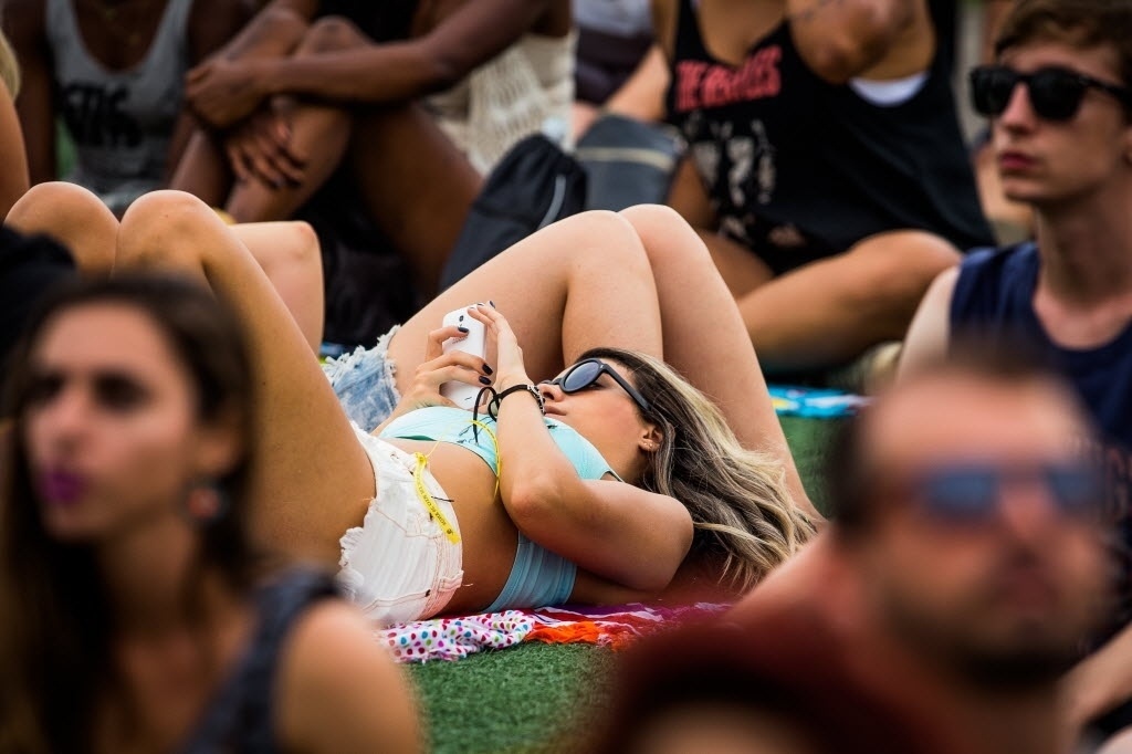 26.set.2015 - Público do Rock in Rio descansa no gramado da Cidade do Rock - Eduardo Anizelli/Folhapress