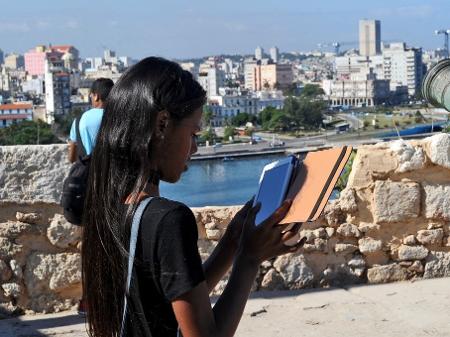 Jovem cubana lê em tablet durante a Feira Internacional do Livro Havana de Havana - Yamil Lage/AFP Photo